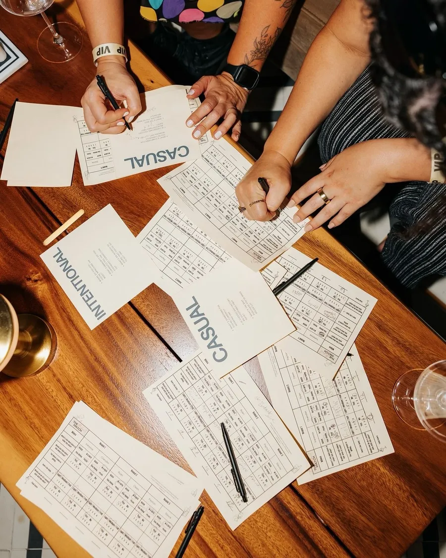 Gäste schreiben an ihren Quizkarten am Tisch